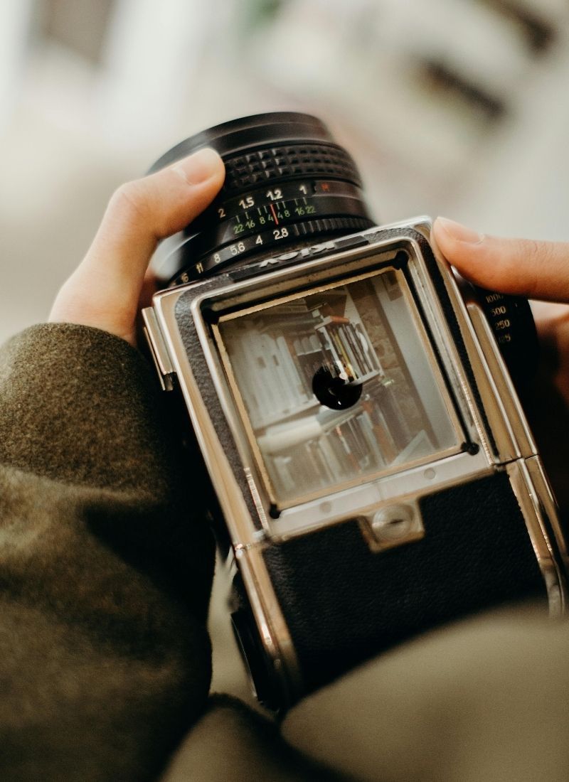 Person holding a vintage analog camera