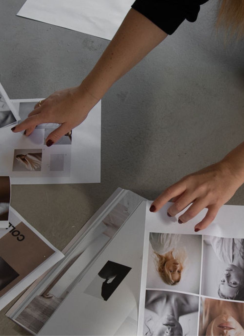 Hands carefully arranging printed photos and moodboard pieces on a minimal floor, evoking a slow, intentional creative process.