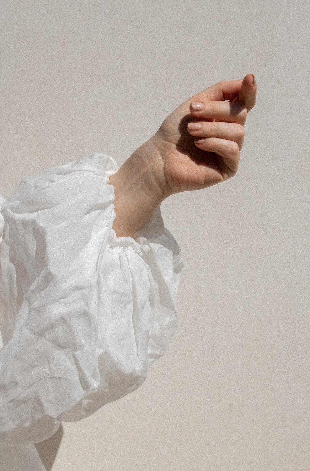 White linen shirt layered atop soft natural textures — minimalist capsule wardrobe inspiration