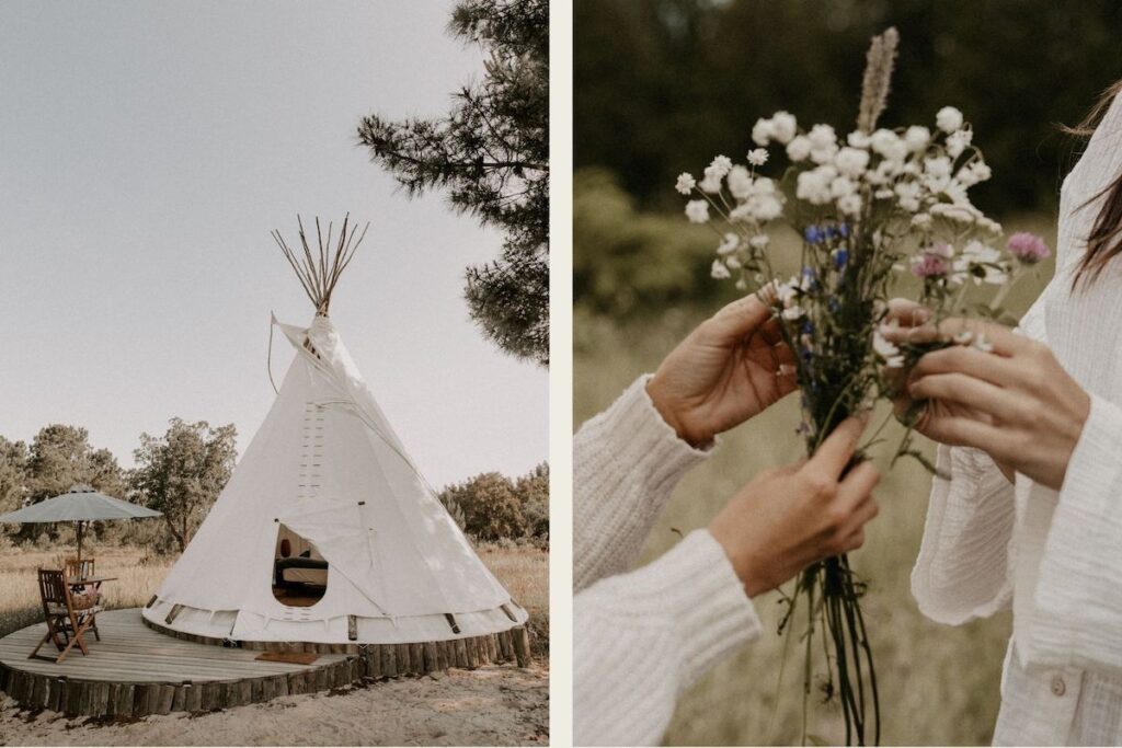 A white canvas tipi on a wooden deck in a sunlit clearing; beside it, two women in soft, textured clothing gently gather wildflowers in a meadow.