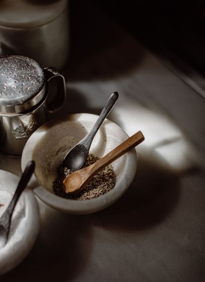 Herbs, pots and spoons on a marble table