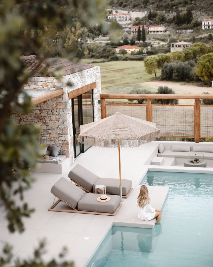 A luxurious poolside in Kefalonia with the blisshunter relaxing by the water, offering a glimpse into the island's leisurely lifestyle and answering "Is Kefalonia worth going to?" with a scene of idyllic relaxation.