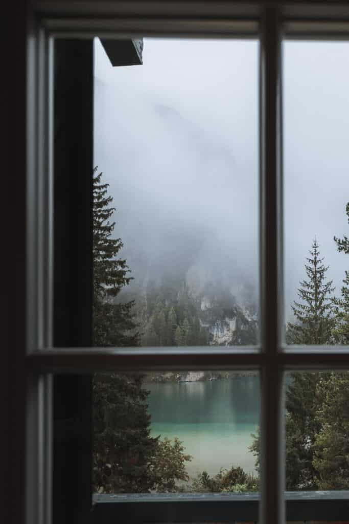 A tranquil lake view from a bedroom window at Hotel Lago di Braies, showcasing the Dolomites' natural splendor which is Lago di Braies, one on the most stunning lakes in the Dolomites.