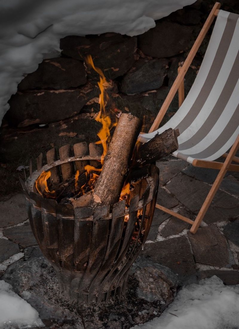 fire logs burning outdoors near a mountain hut