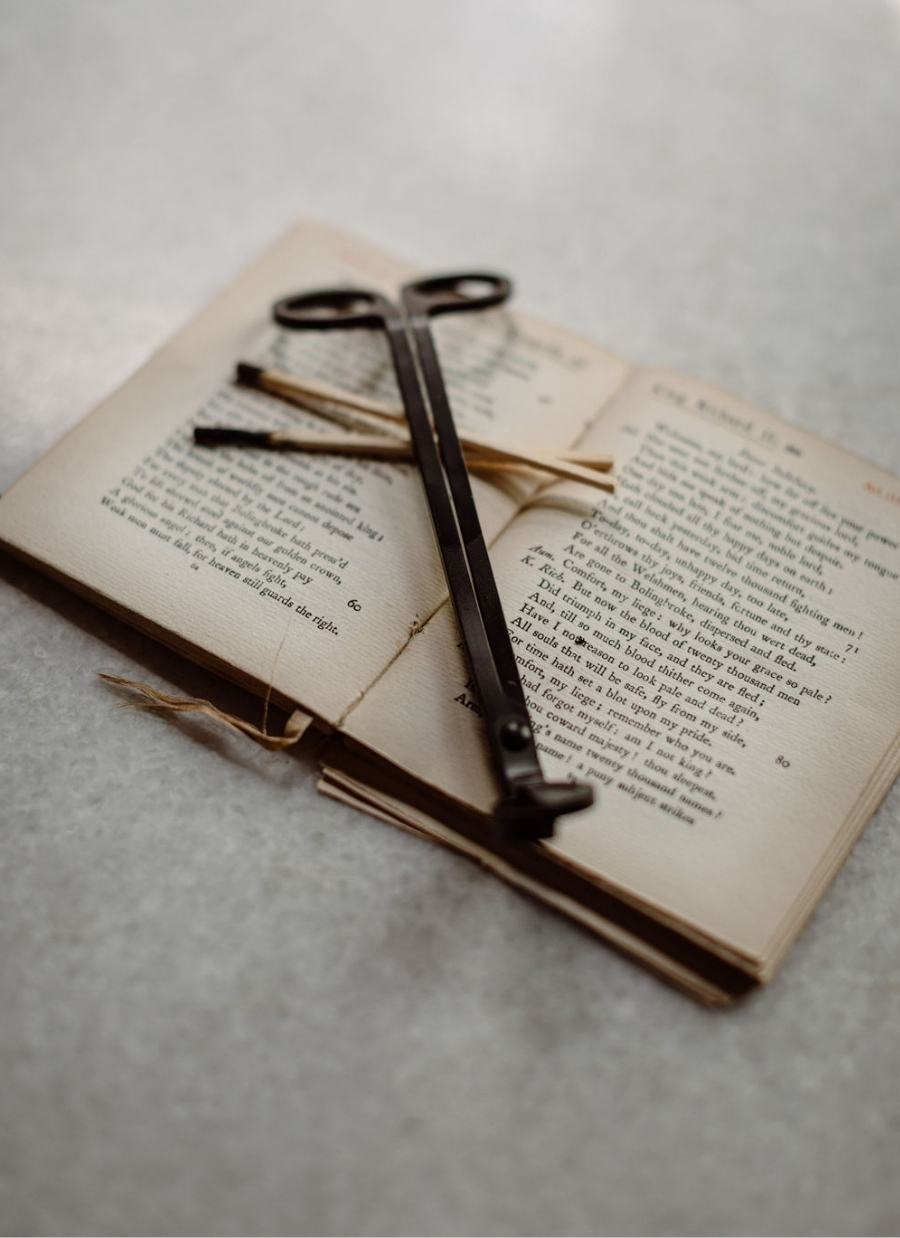 Flatlay of a peotry book and a candle cutter