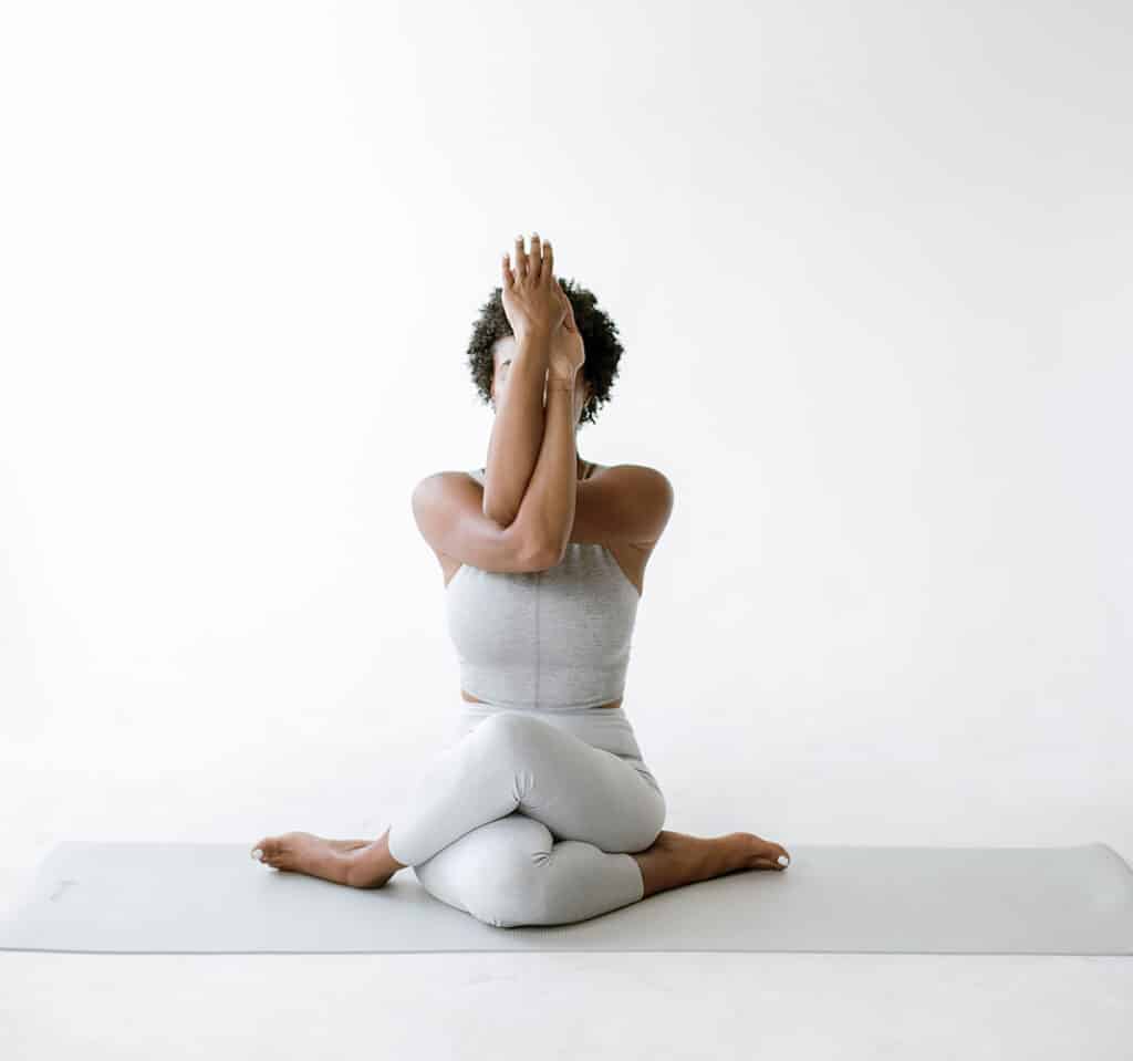 A woman in a serene yoga pose, practicing mindfulness on a mat, embodying inner peace after reading books about Confidence.