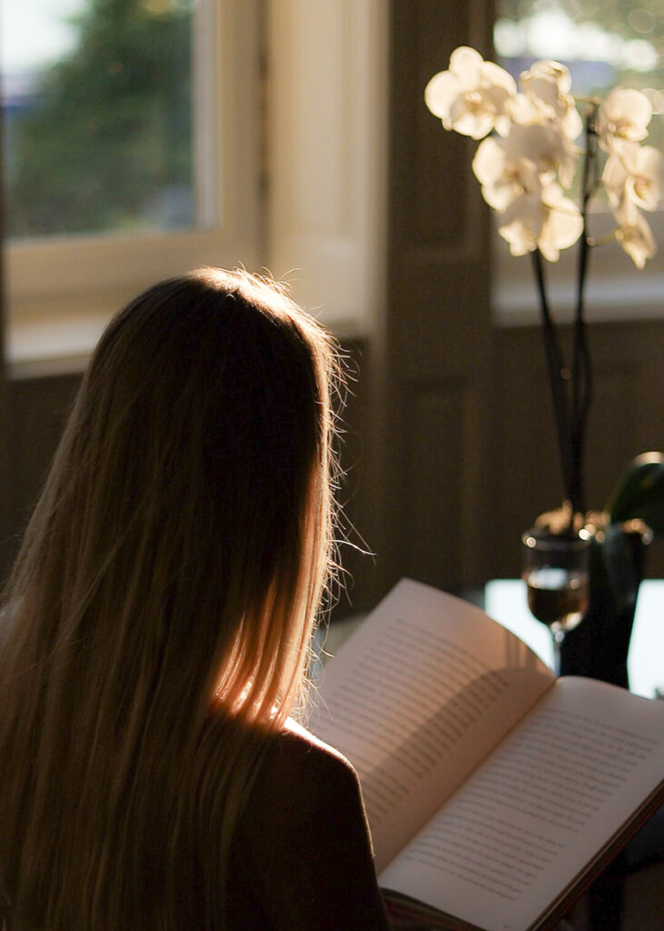 Blonde woman reading a book in the Gresham Palace Four Seasons Presidential Suite