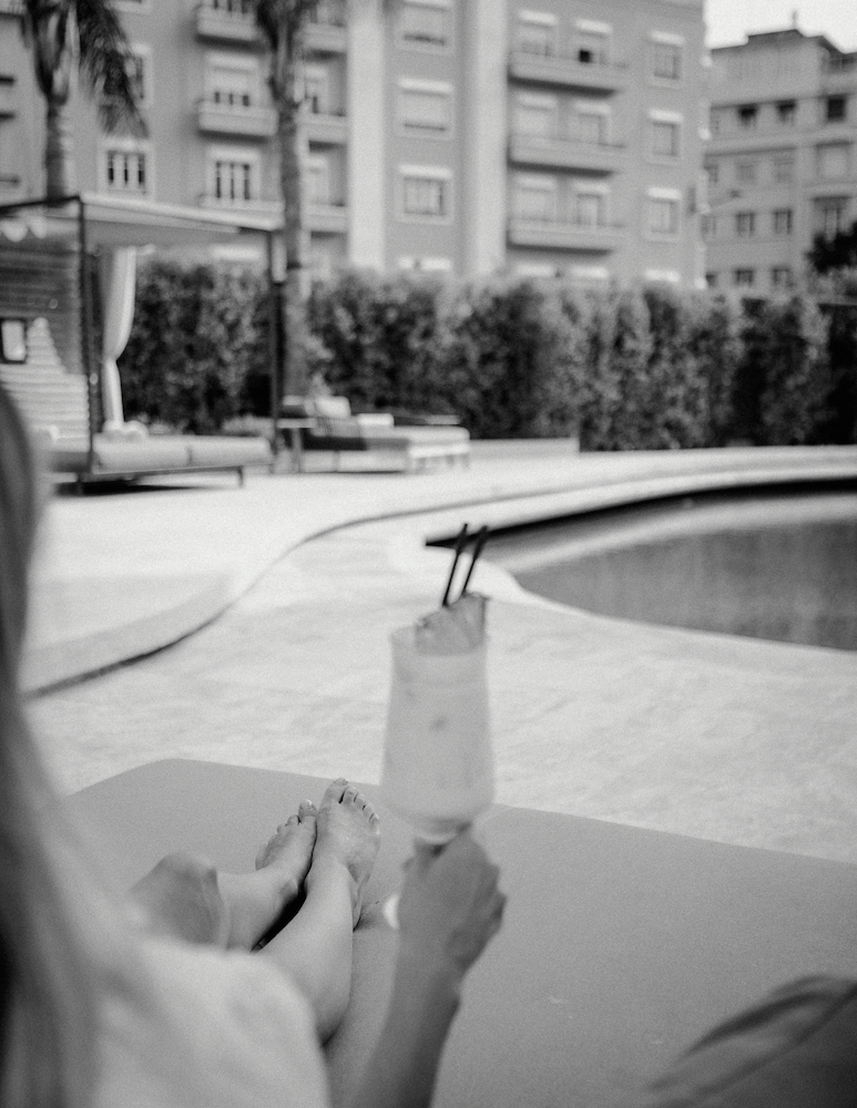 Woman sitting at the pool with cocktail in hand
