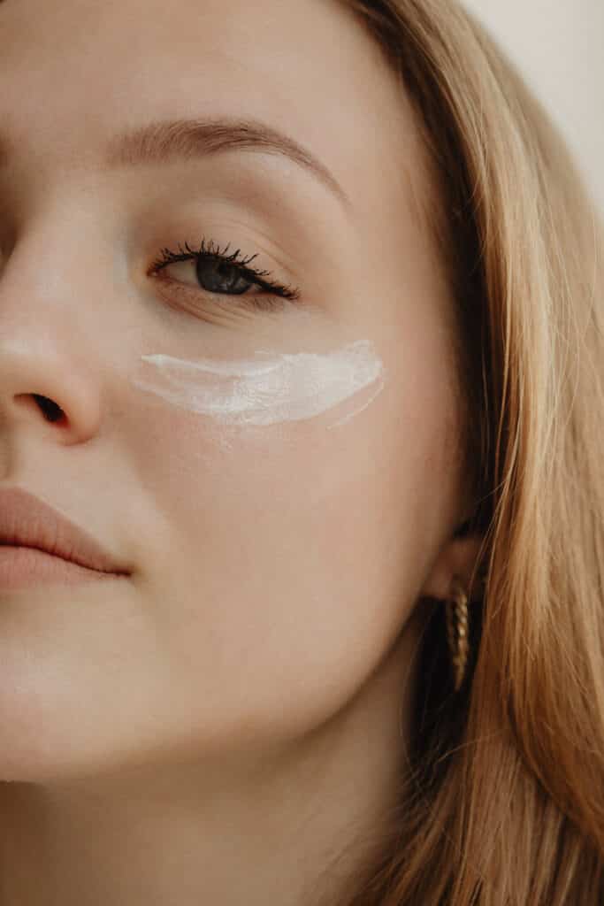 Close-up of a woman's face with a swipe of mineral sunscreen under her eye, symbolizing skincare protection.