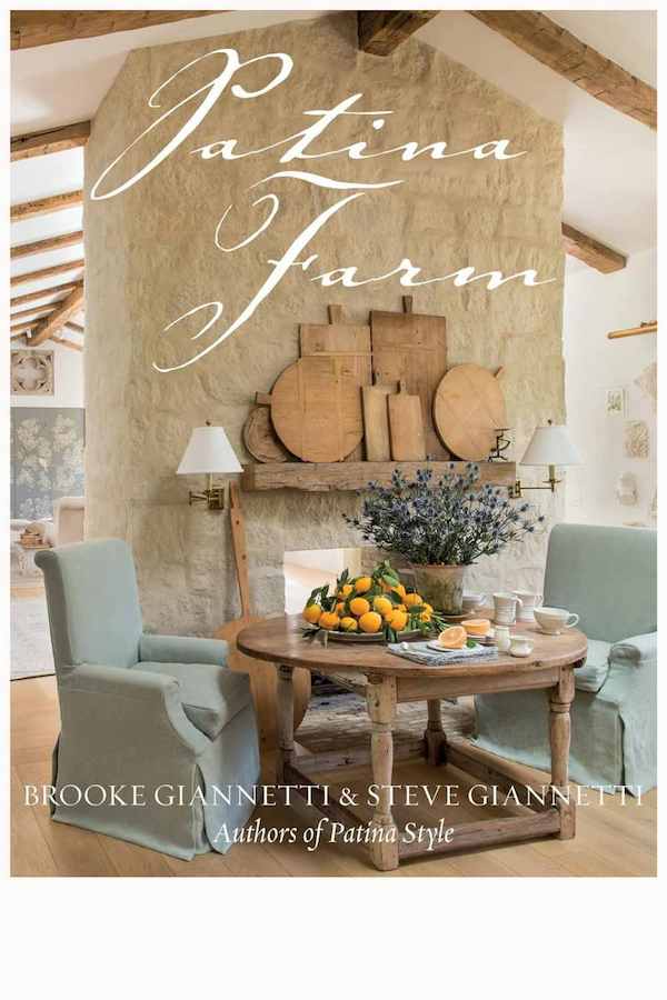 Luxury books: 'Patina Farm' book cover featuring a rustic chic interior with a stone fireplace, wooden decor, and elegant blue armchairs.