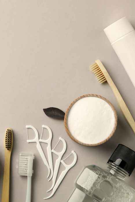 Is Invisalign Worth it for adults? Assorted dental care tools are displayed neatly, including a toothbrush, flossers, and a bottle of mouthwash, essential for maintaining oral hygiene during Invisalign treatment.