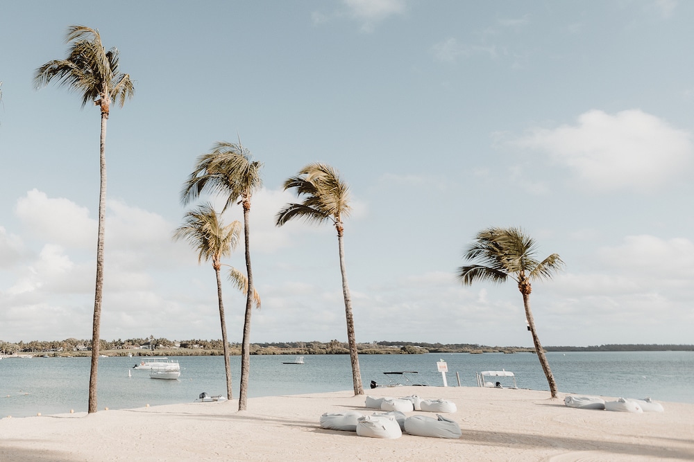 Palm trees sway over the tranquil beach at the Four Seasons at Anahita in Mauritius, painting a picture of paradise that beckons visitors to discover if the island is worth visiting.