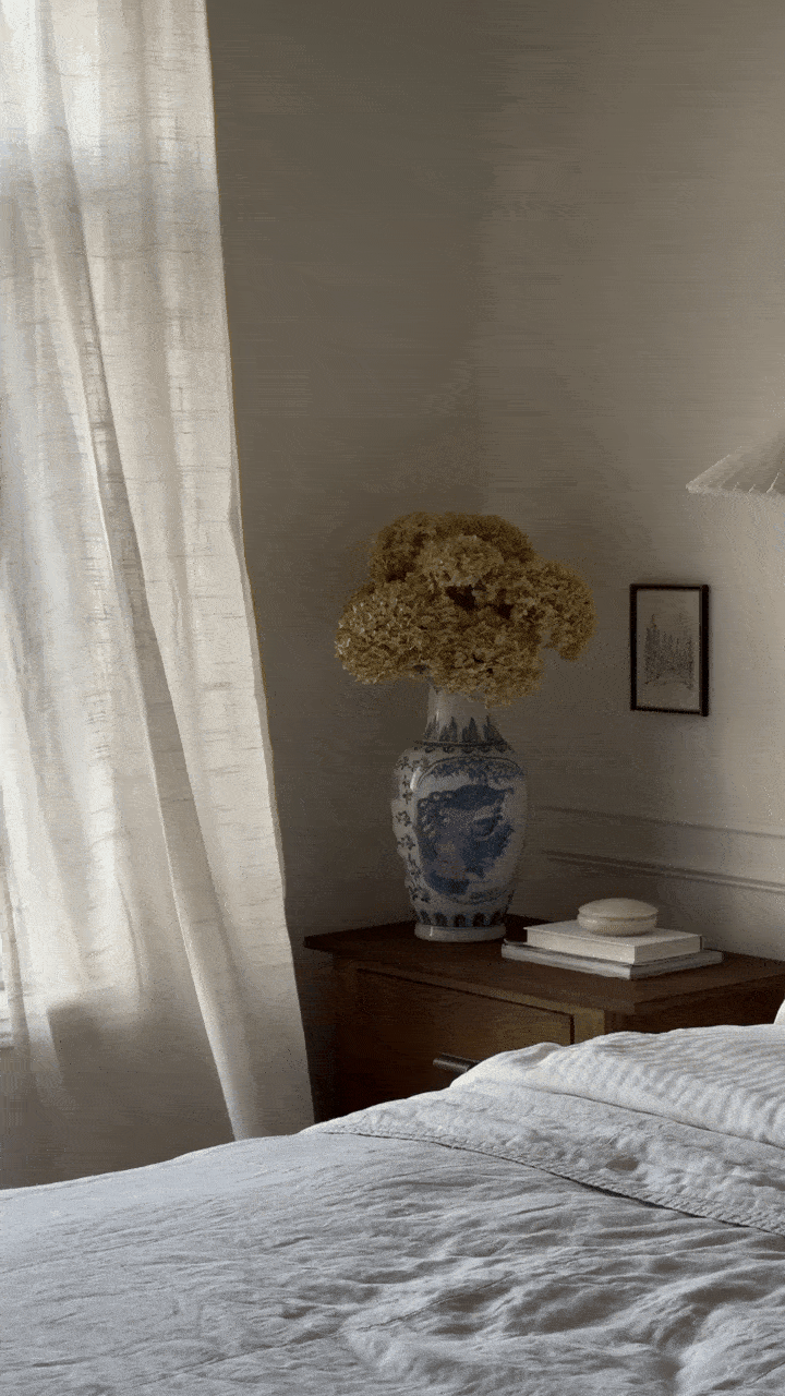 Gif of a linen curtain waving in the wind in a simple classic bedroom