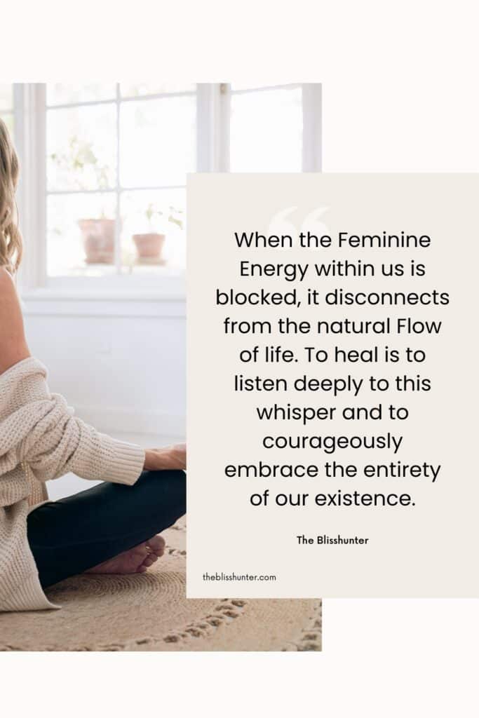 A woman sitting cross-legged by a window, reflecting on her inner world, with a quote from The BlissHunter about healing blocked feminine energy and signs of Blocked Feminine energy.